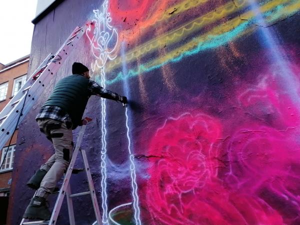 Exclusively in France, the Australian street artist paints the walls in fluo for La Vallée Village